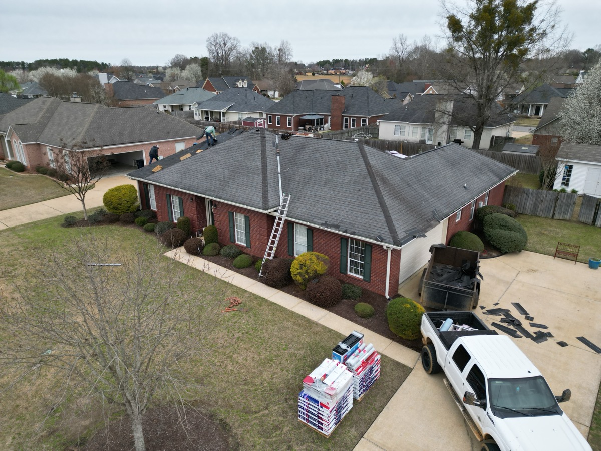 Before: storm-damaged shingle roof in Tuscaloosa showing missing and curling shingles